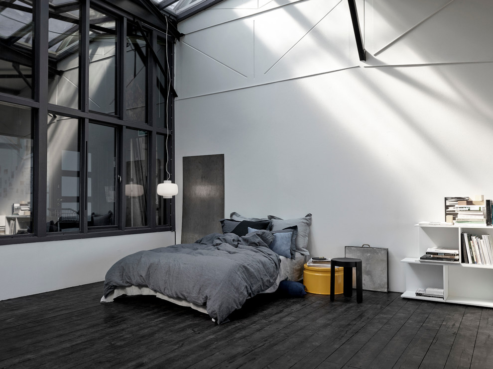 Ejemplo de dormitorio principal nórdico grande sin chimenea con paredes blancas y suelo de madera oscura