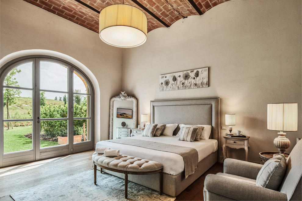 Aménagement d'une grande chambre parentale méditerranéenne avec un mur gris, parquet clair, un sol beige et un plafond voûté.
