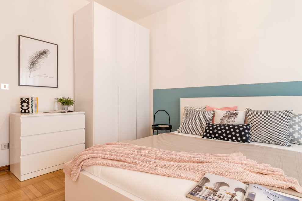 Foto de dormitorio actual con paredes blancas, suelo de madera en tonos medios y suelo marrón