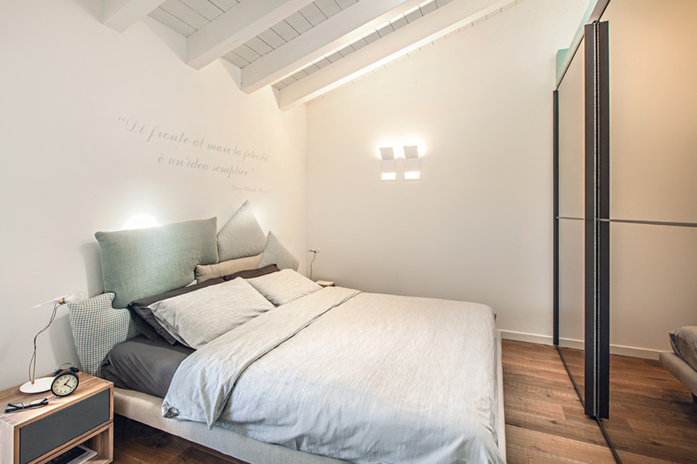 Immagine di una camera degli ospiti contemporanea con pareti bianche, pavimento in legno massello medio e pavimento marrone