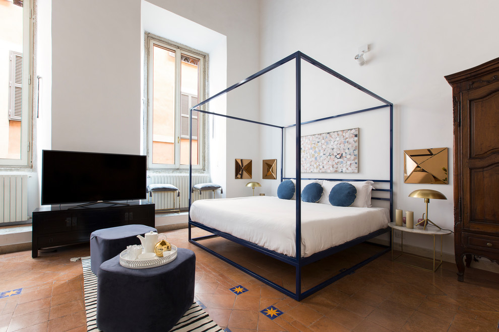 Стильный дизайн: спальня в современном стиле с белыми стенами, полом из терракотовой плитки и красным полом - последний тренд