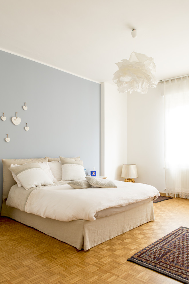 Réalisation d'une chambre parentale design de taille moyenne avec un mur multicolore et parquet clair.