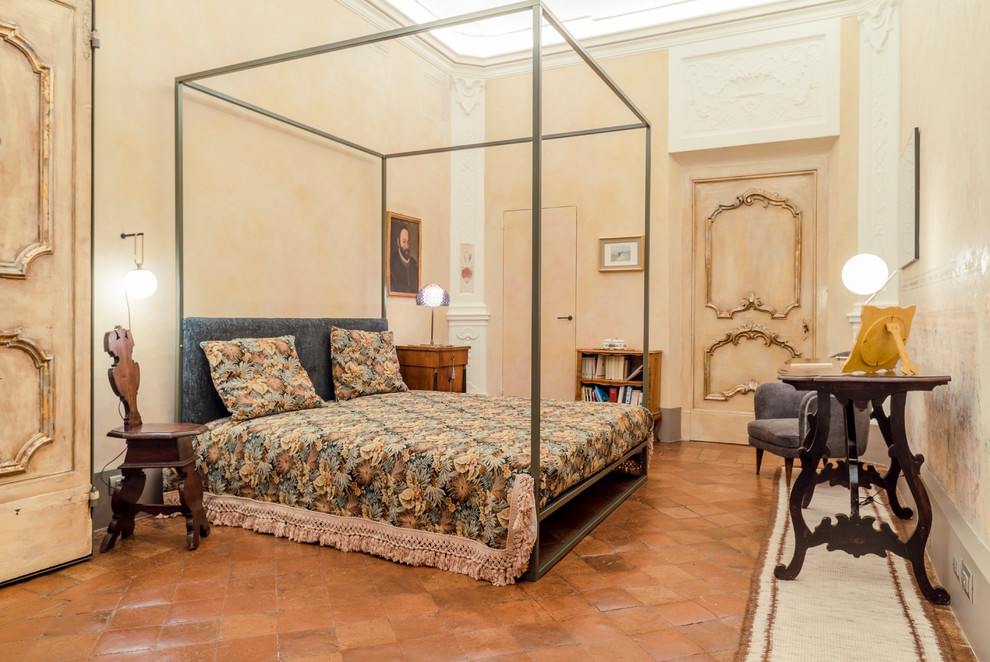Ispirazione per una camera da letto mediterranea con pareti beige, pavimento in terracotta e pavimento marrone