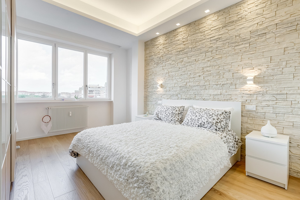 Modern inredning av ett sovrum, med vita väggar, ljust trägolv och beiget golv