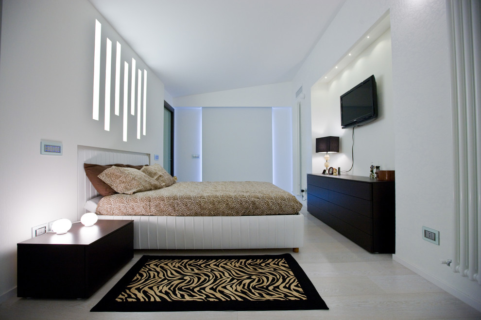 Foto de dormitorio principal y televisión contemporáneo grande con paredes blancas y suelo de madera clara
