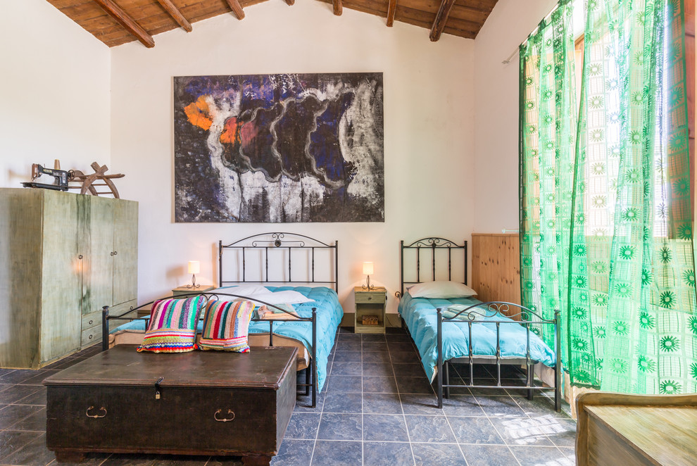 カターニア／パルレモにある広いエクレクティックスタイルのおしゃれな客用寝室 (スレートの床、白い壁) のインテリア