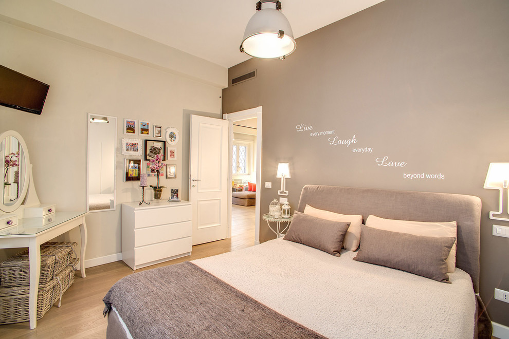Small eclectic master bedroom in Rome with grey walls, light hardwood flooring and beige floors.