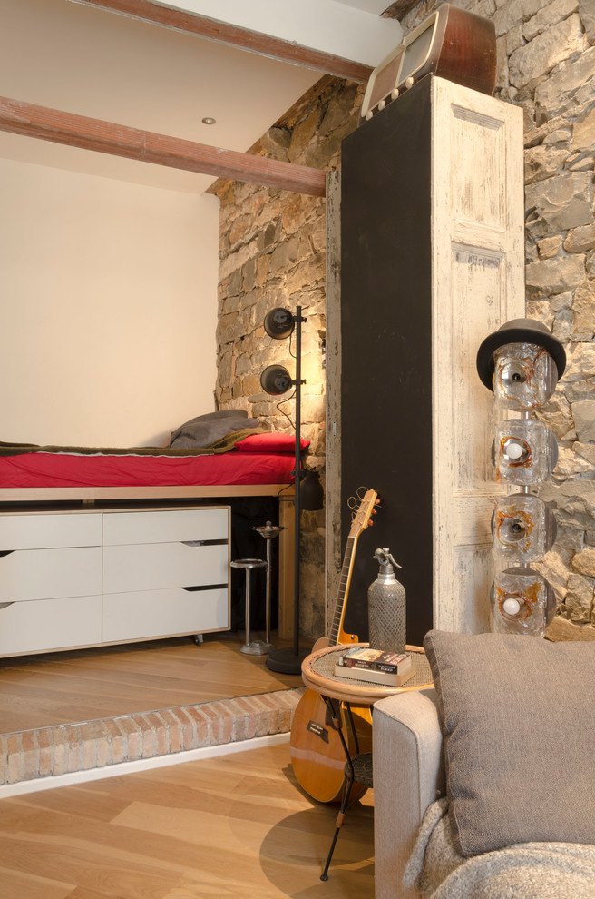 Immagine di una camera da letto stile loft boho chic di medie dimensioni con pavimento in legno massello medio