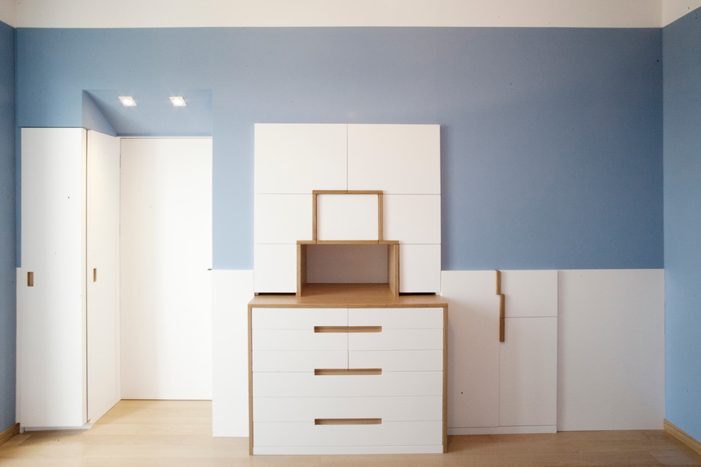 Cette photo montre une chambre parentale moderne de taille moyenne avec parquet clair et un mur bleu.