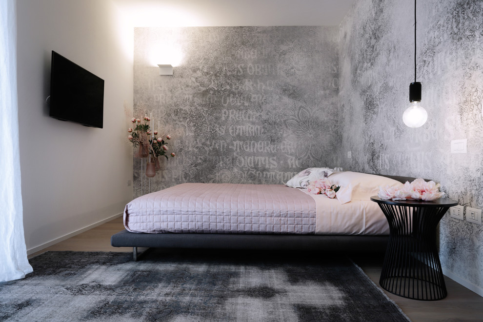This is an example of a contemporary grey and pink bedroom in Other with black walls, light hardwood flooring and beige floors.