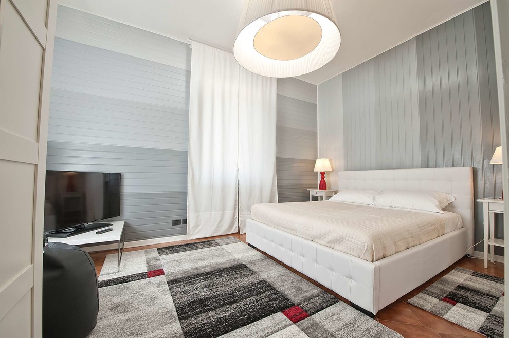 Modelo de dormitorio principal contemporáneo de tamaño medio con paredes grises y suelo marrón