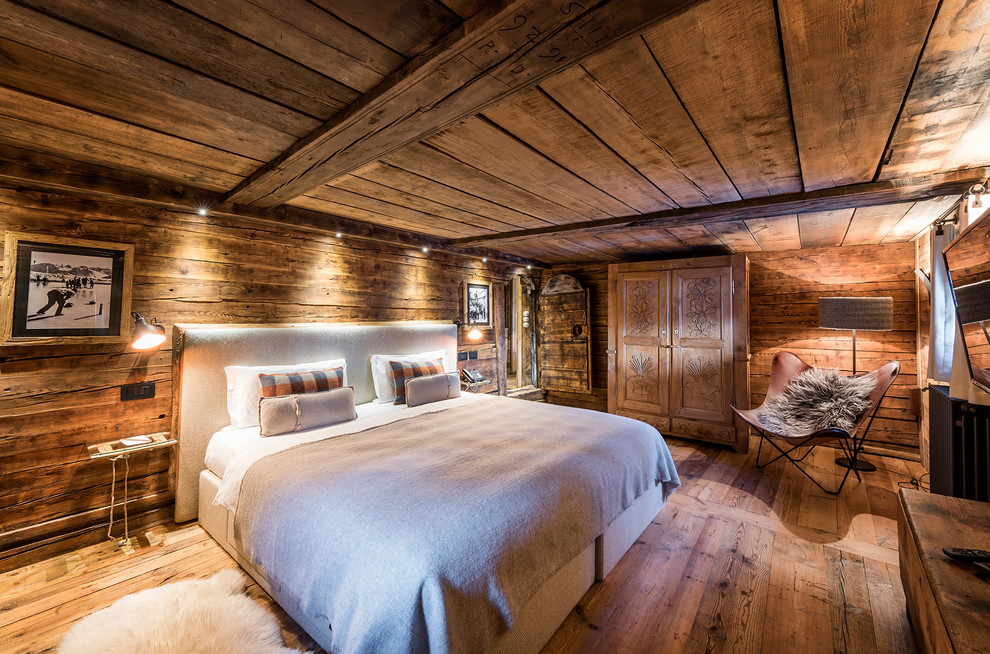 Idee per una camera da letto rustica con pareti marroni, pavimento in legno massello medio e pavimento marrone