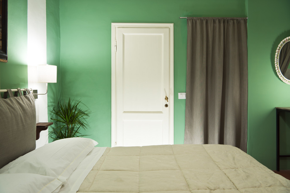 Modelo de dormitorio principal actual pequeño con paredes verdes, suelo de baldosas de terracota y suelo naranja