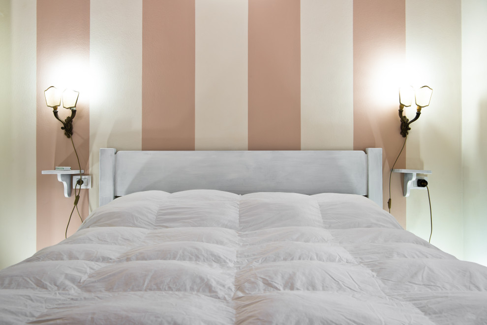 Immagine di una piccola camera matrimoniale design con pareti beige, pavimento in terracotta e pavimento arancione