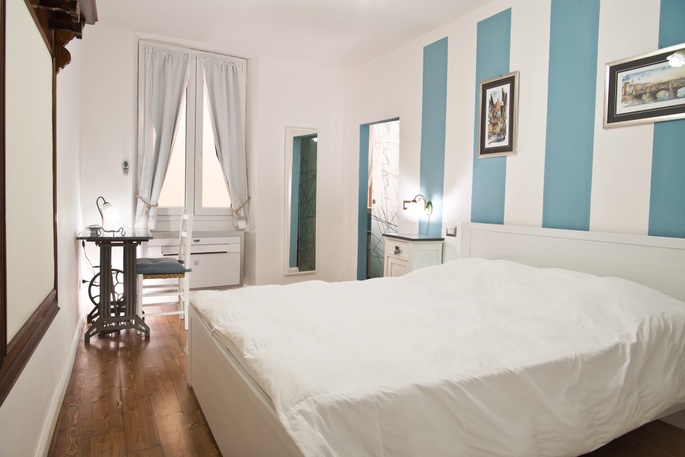 Foto de dormitorio principal actual pequeño con paredes blancas, suelo de madera clara y suelo marrón