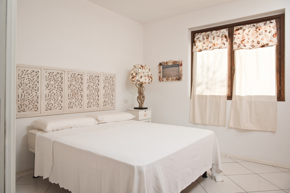 Immagine di una piccola camera matrimoniale stile marinaro con pareti bianche, pavimento con piastrelle in ceramica e pavimento bianco