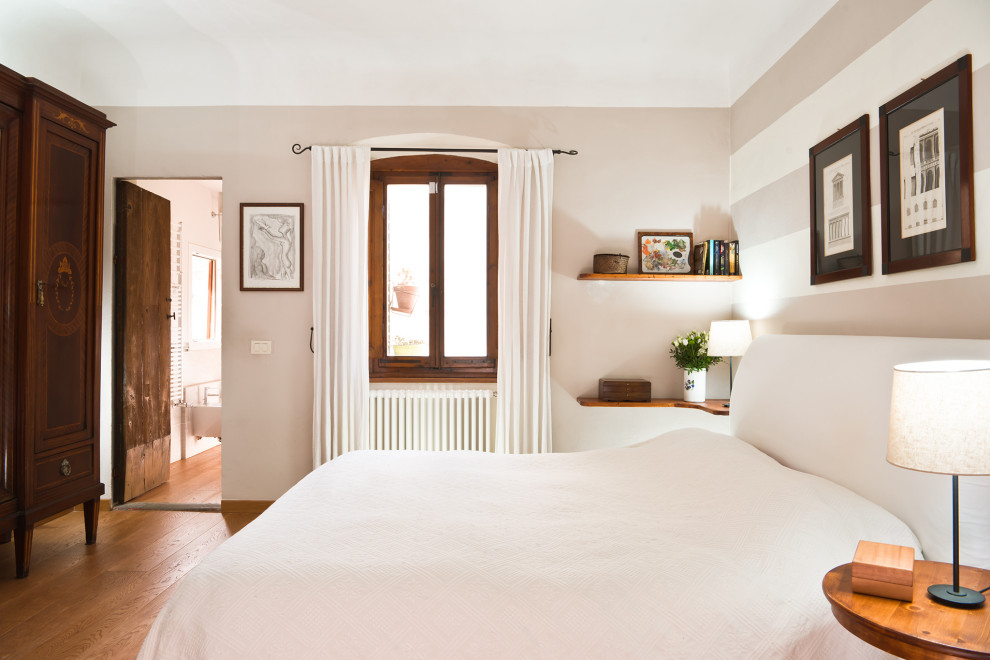 Exemple d'une petite chambre parentale romantique avec un mur blanc, parquet clair, une cheminée standard, un manteau de cheminée en pierre et un sol marron.