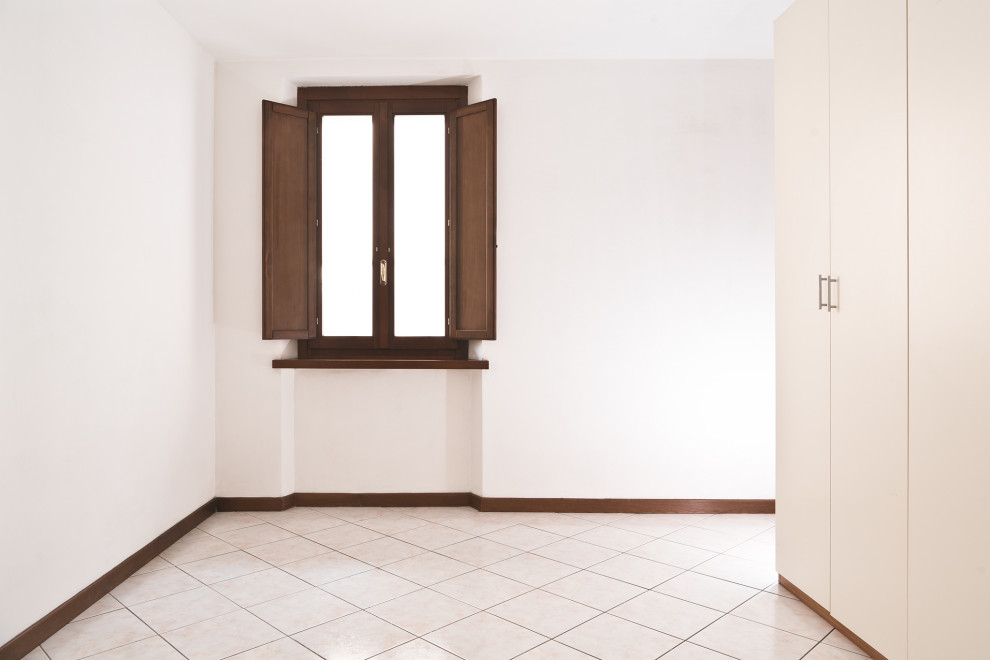 Esempio di una piccola camera da letto contemporanea con pavimento con piastrelle in ceramica, pavimento beige e pareti bianche