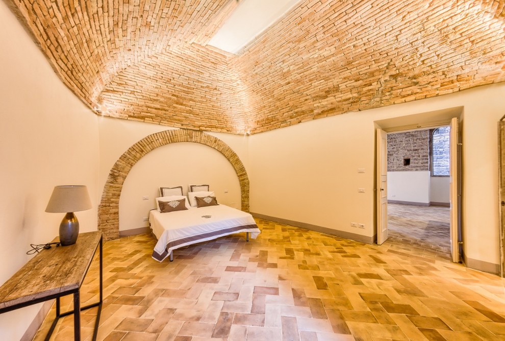 Foto de habitación de invitados mediterránea de tamaño medio con paredes beige y suelo de baldosas de terracota