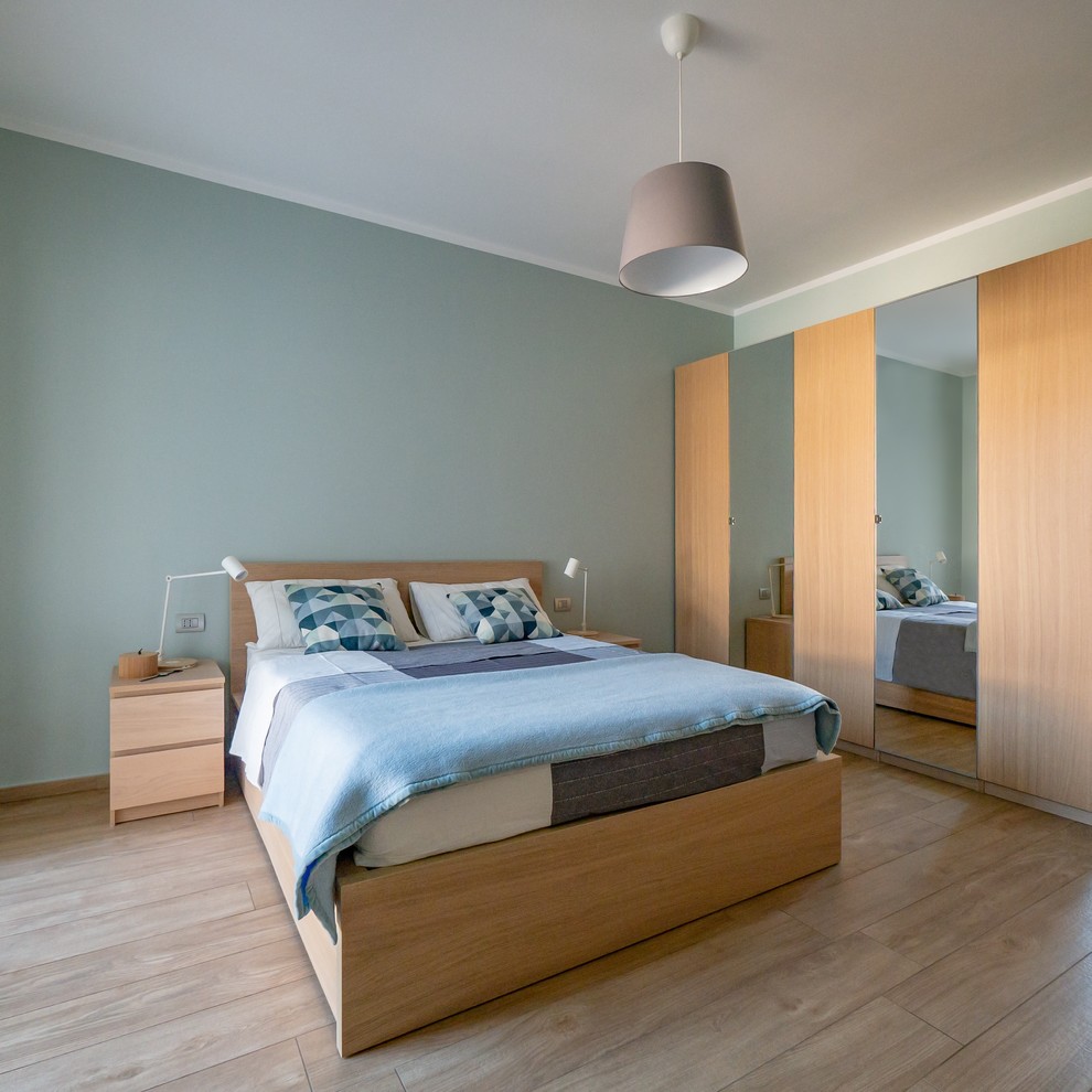 Modelo de dormitorio principal nórdico de tamaño medio con paredes azules, suelo de baldosas de porcelana y suelo beige