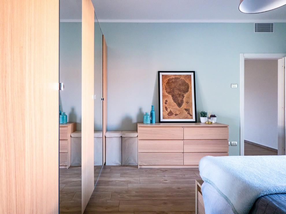 Ejemplo de dormitorio principal escandinavo de tamaño medio con paredes azules, suelo de baldosas de porcelana y suelo beige