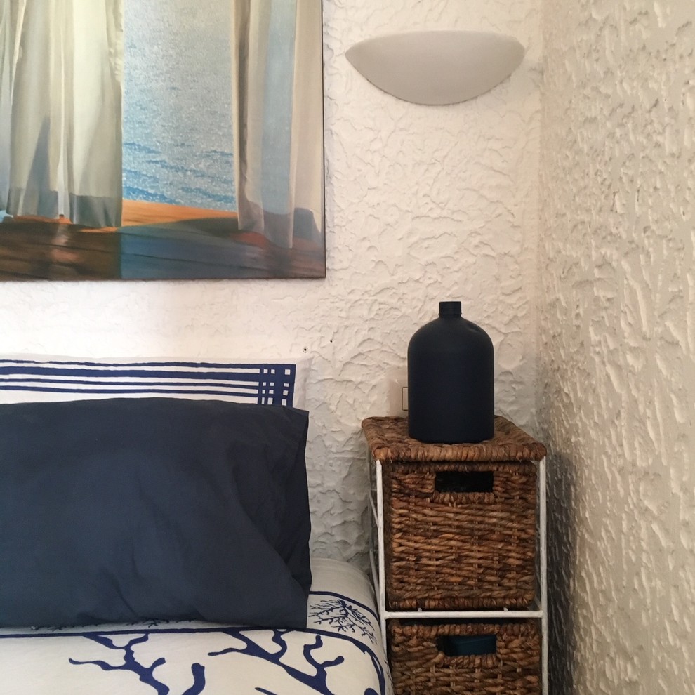 Diseño de dormitorio principal mediterráneo pequeño con paredes blancas, suelo de baldosas de terracota y suelo marrón