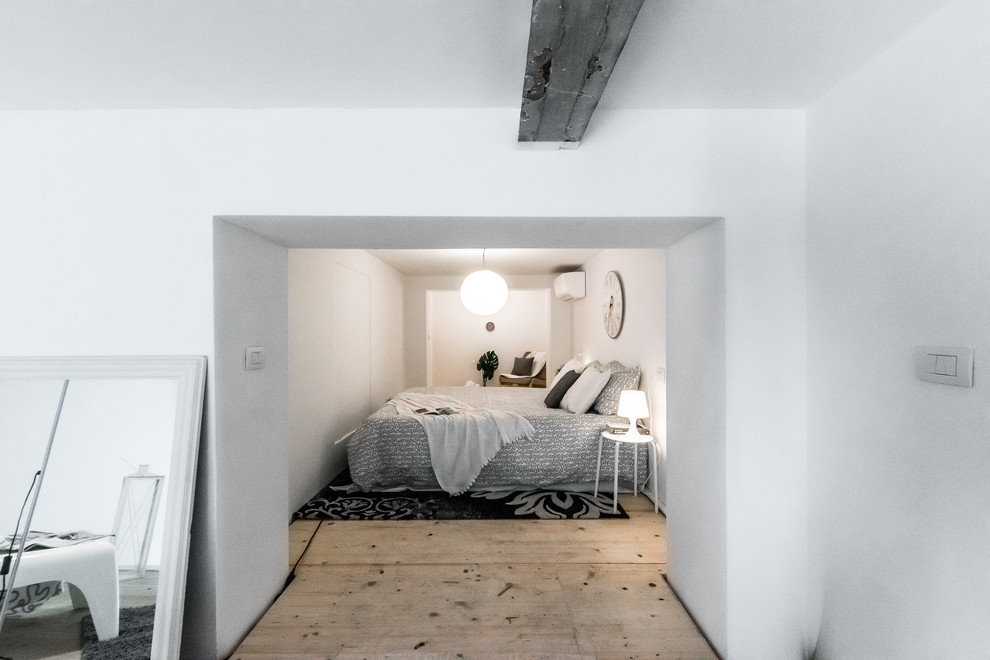 Immagine di una camera da letto stile loft nordica di medie dimensioni con pareti bianche, parquet chiaro, nessun camino e pavimento marrone