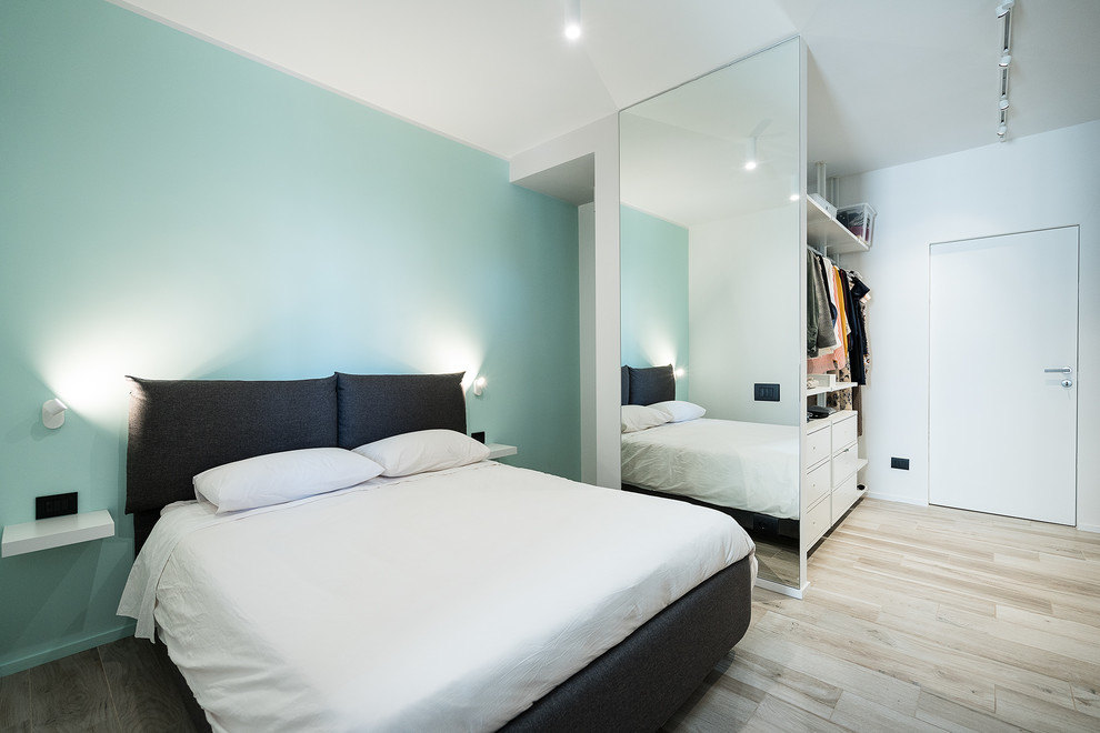 Foto di una camera matrimoniale minimal con pareti blu, parquet chiaro e pavimento beige