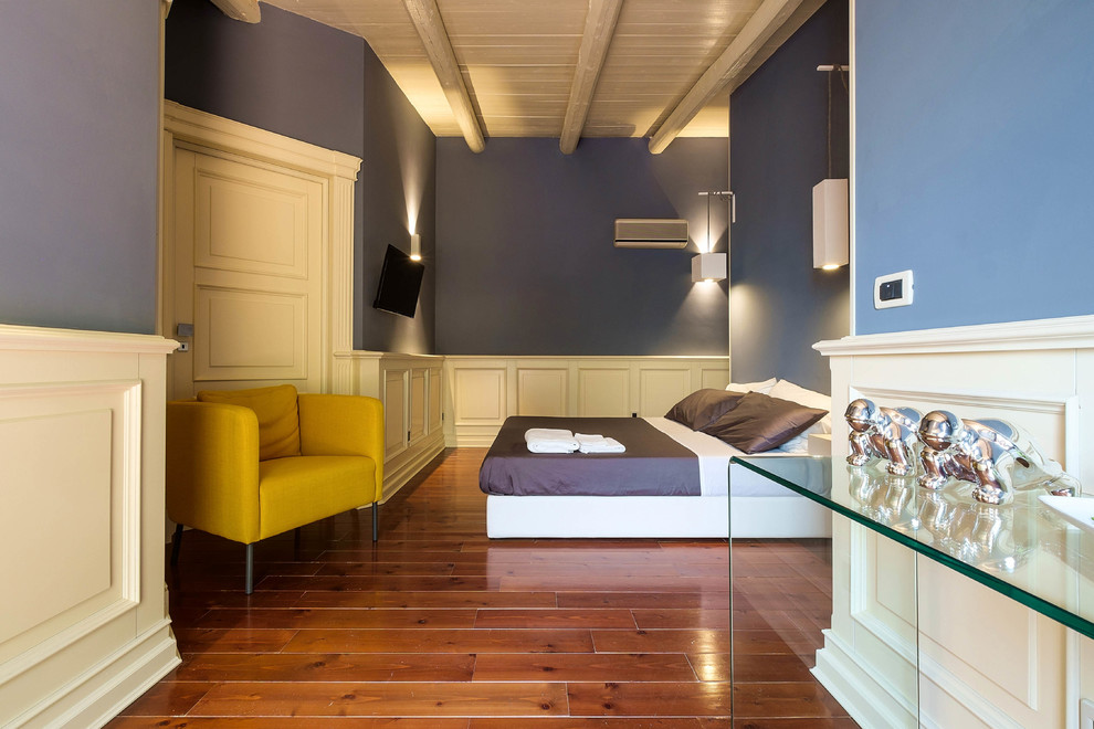Diseño de habitación de invitados actual grande con suelo de madera en tonos medios y paredes azules