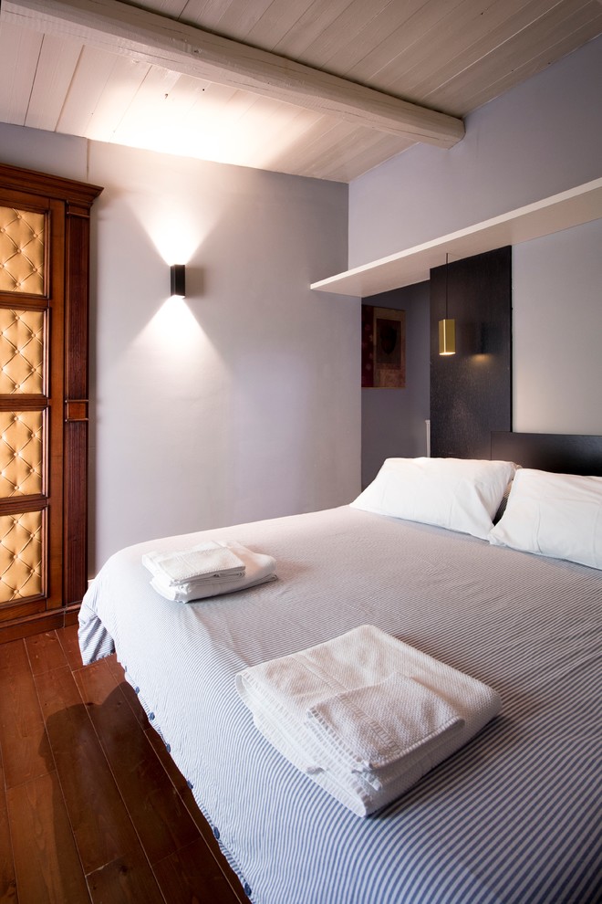 Diseño de habitación de invitados contemporánea de tamaño medio con paredes grises y suelo de madera en tonos medios