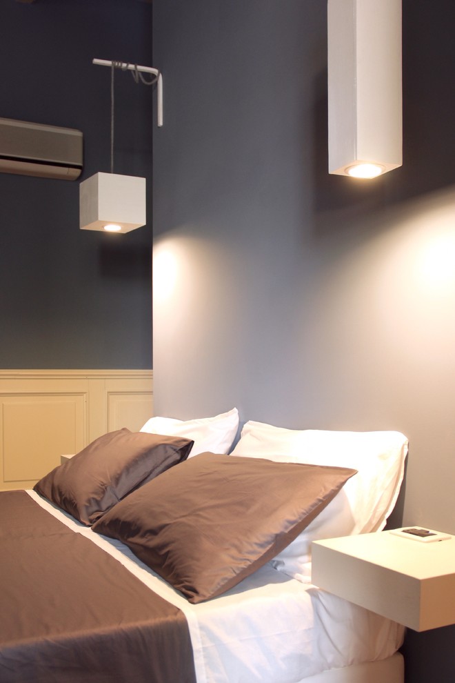 Modelo de habitación de invitados actual grande con paredes azules y suelo de madera en tonos medios