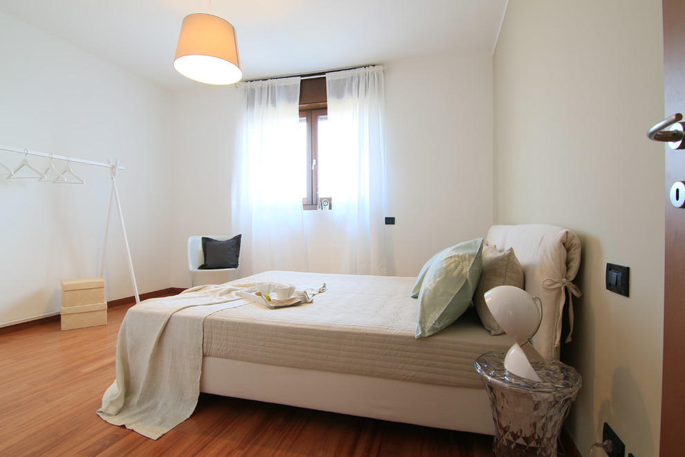 Foto di una camera matrimoniale minimal di medie dimensioni con pareti beige e parquet chiaro