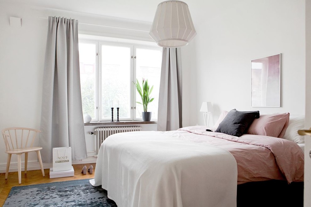 Свежая идея для дизайна: спальня в скандинавском стиле с белыми стенами, паркетным полом среднего тона и коричневым полом - отличное фото интерьера