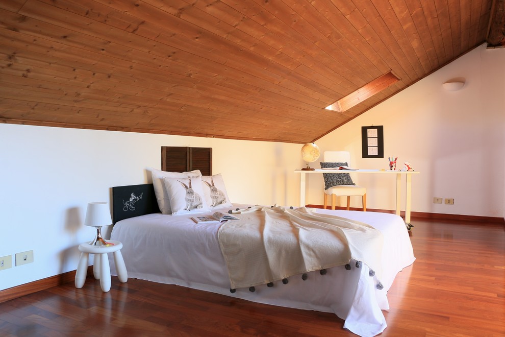 Bedroom - large country loft-style medium tone wood floor bedroom idea in Milan with white walls