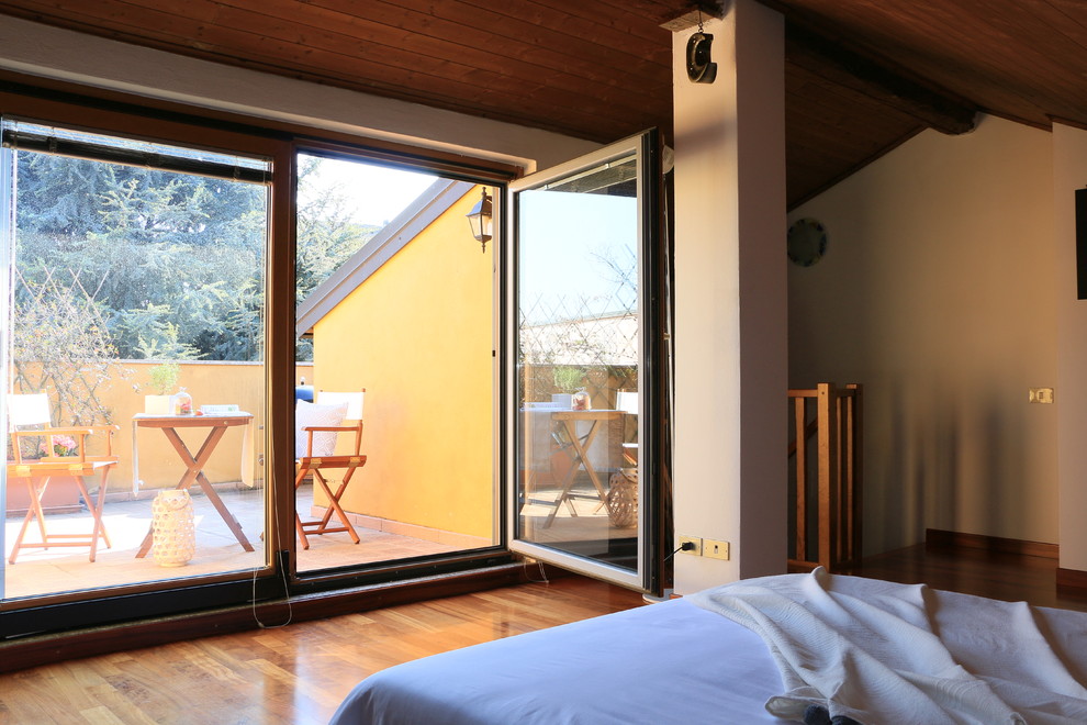 Esempio di una grande camera da letto stile loft contemporanea con pareti bianche e pavimento in legno massello medio