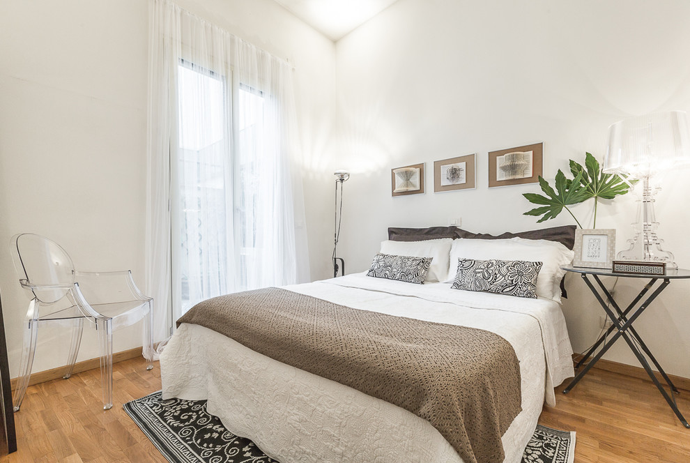 ボローニャにある中くらいなコンテンポラリースタイルのおしゃれな主寝室 (白い壁、無垢フローリング)