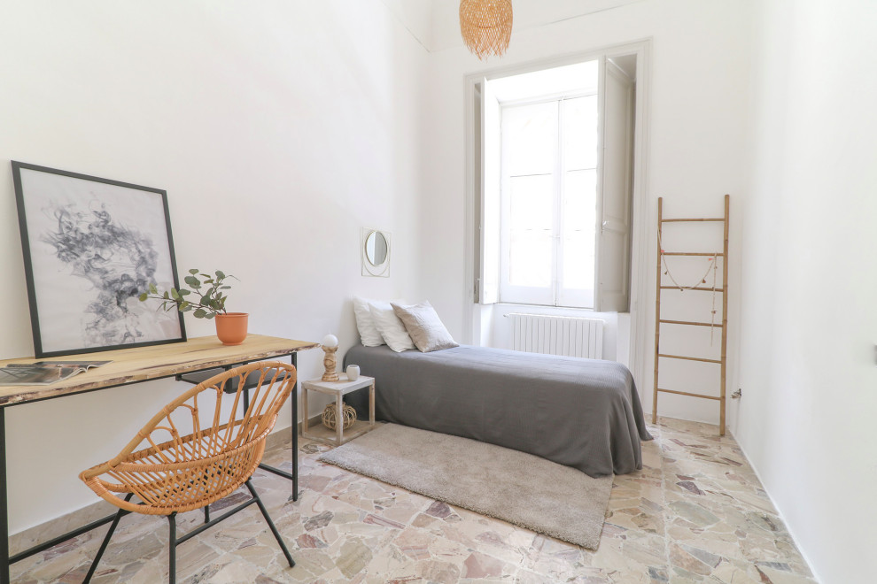 Imagen de dormitorio costero con paredes blancas y suelo beige