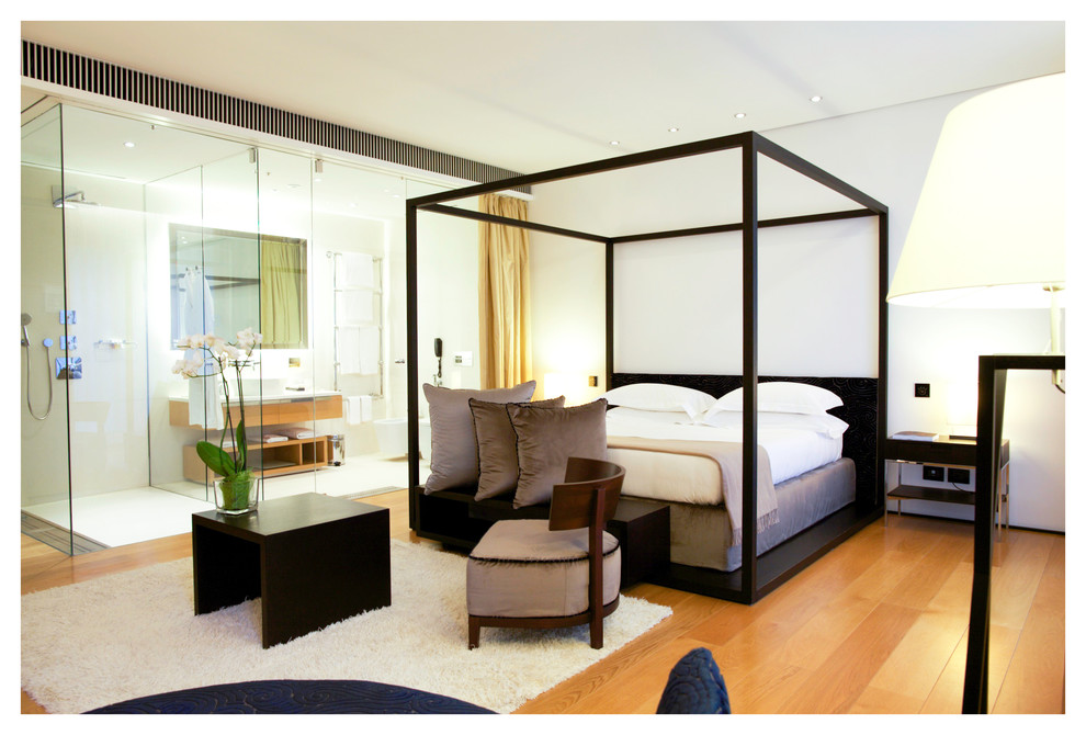 На фото: большая хозяйская спальня в стиле модернизм с белыми стенами, паркетным полом среднего тона и коричневым полом с