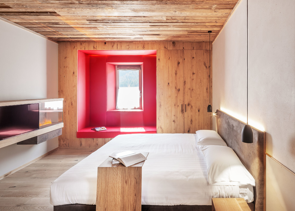 Idee per una camera da letto moderna con pareti bianche, parquet chiaro e camino classico