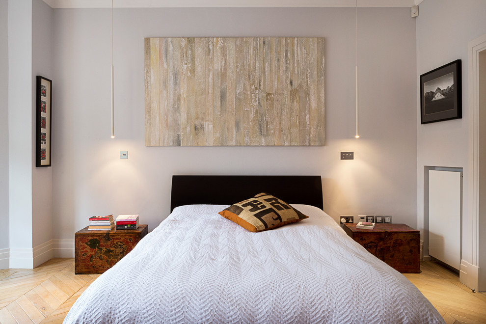 Imagen de dormitorio principal actual con paredes grises y suelo de madera clara