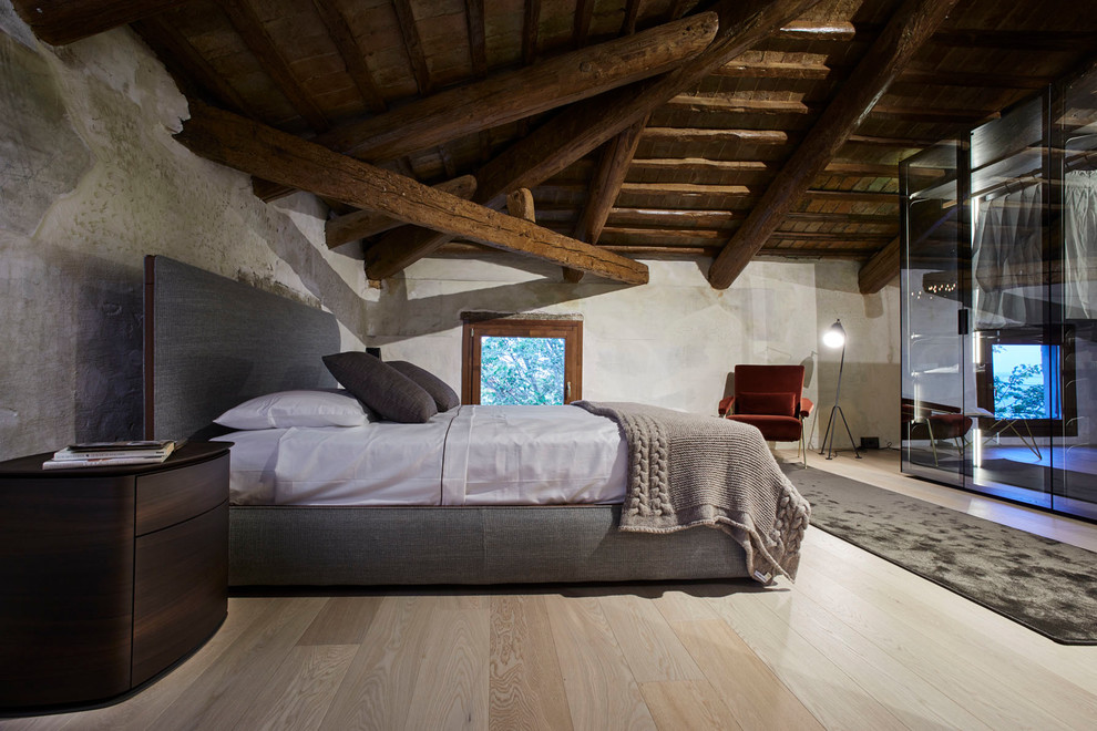 Ejemplo de dormitorio principal rural grande sin chimenea con suelo de madera clara