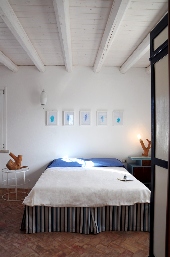 Стильный дизайн: спальня в средиземноморском стиле с белыми стенами и кирпичным полом - последний тренд