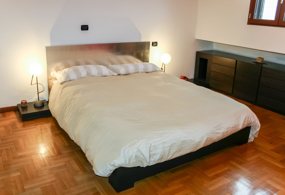 Idee per una piccola camera matrimoniale minimalista con pareti rosse e pavimento in legno massello medio