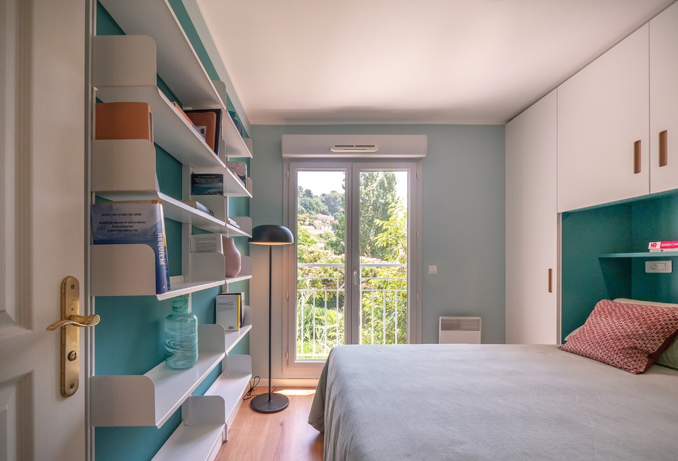 Modelo de dormitorio principal contemporáneo pequeño con paredes verdes y suelo de madera clara