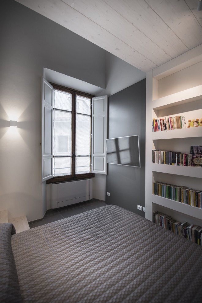 Modelo de dormitorio tipo loft minimalista de tamaño medio con paredes blancas, suelo de baldosas de porcelana, suelo gris, madera y panelado
