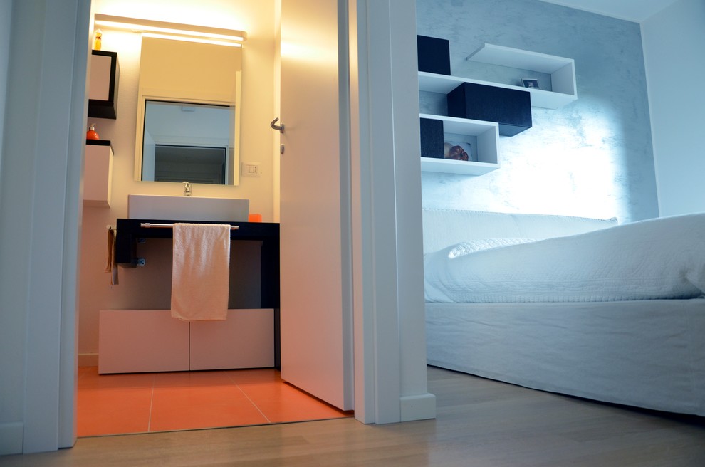 Idée de décoration pour une petite chambre parentale minimaliste avec un mur gris et parquet clair.