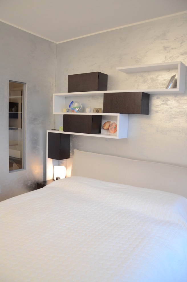 Kleines Modernes Hauptschlafzimmer mit grauer Wandfarbe und hellem Holzboden in Mailand