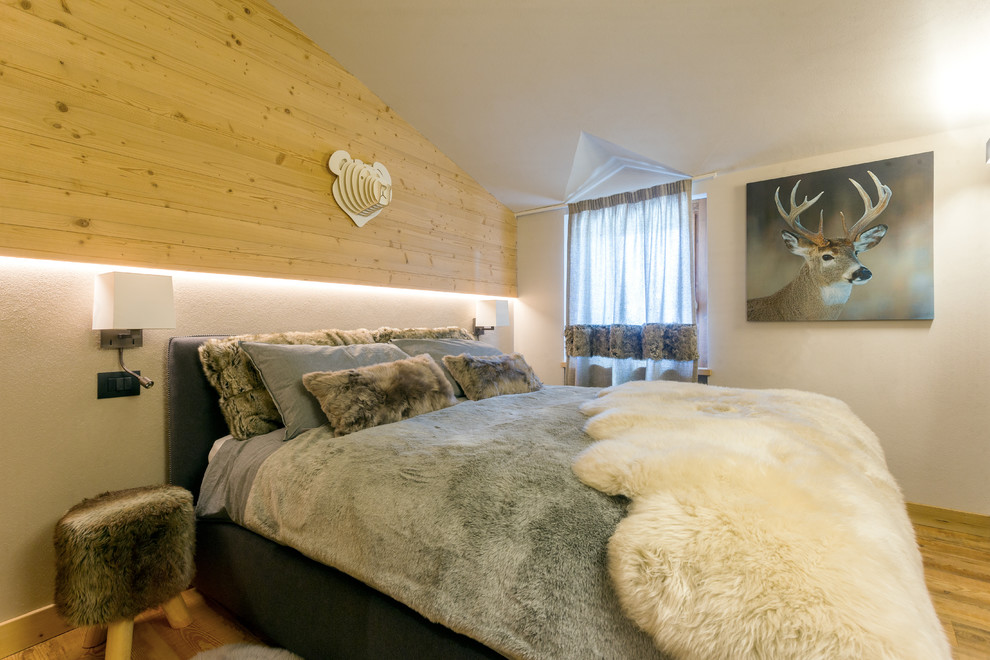 Rustikales Hauptschlafzimmer mit braunem Holzboden und weißer Wandfarbe in Sonstige