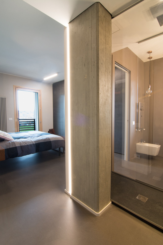Mittelgroßes Industrial Hauptschlafzimmer mit grauer Wandfarbe, Betonboden und grauem Boden in Florenz