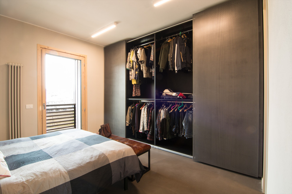 Imagen de dormitorio principal urbano de tamaño medio con paredes grises, suelo de cemento y suelo gris